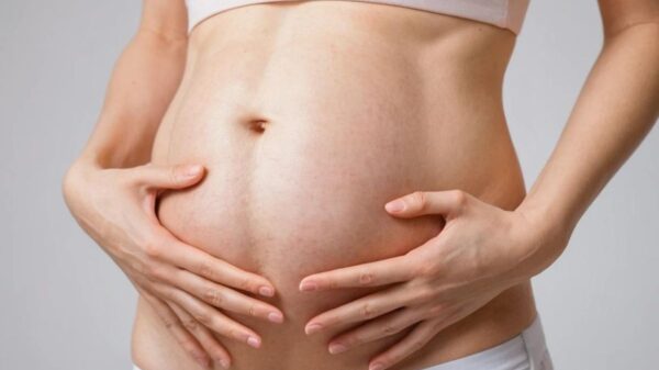 Image showing a woman gently massaging her belly area, symbolizing care and attention to loose skin after pregnancy.